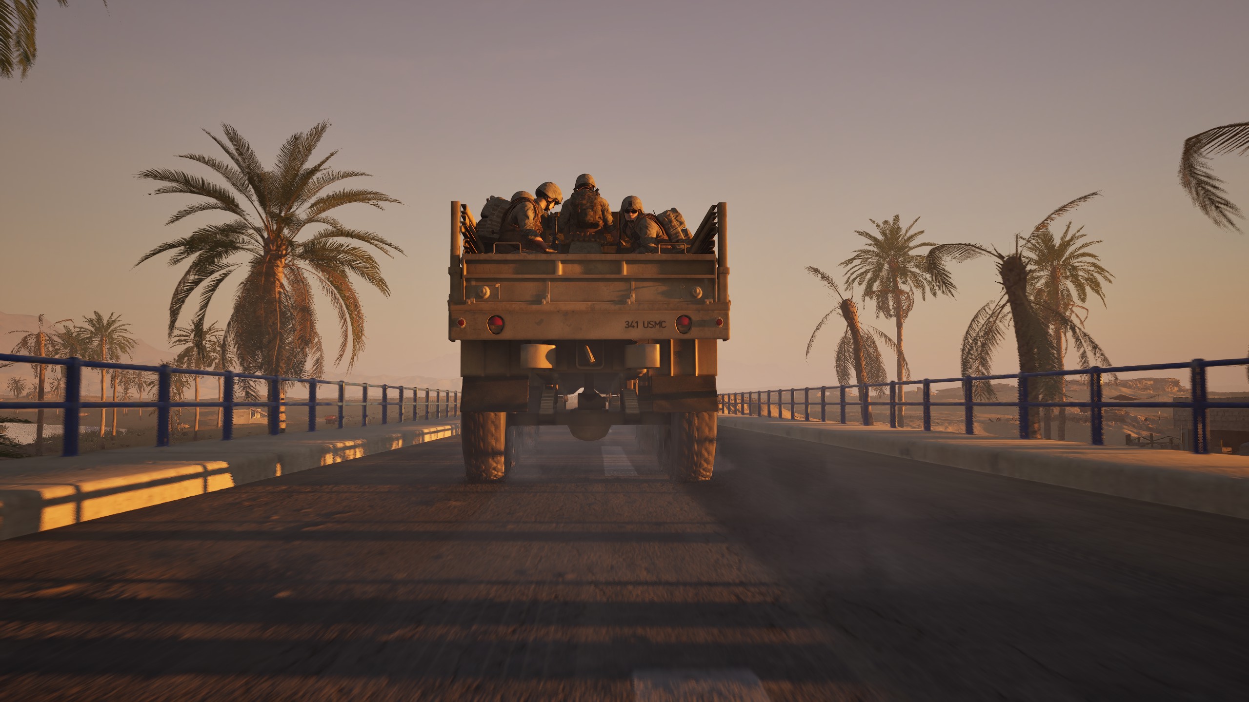 Soldiers riding in a truck at golden hour